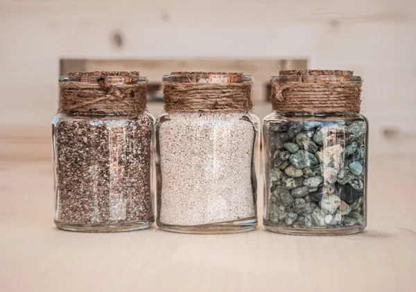 Small glass jars with sand and stones from the beach — Stock Photo, Image