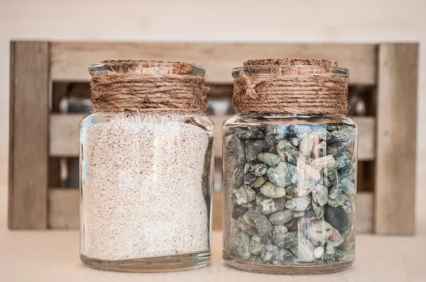 Pequenos frascos de vidro com areia e pedras da praia — Fotografia de Stock