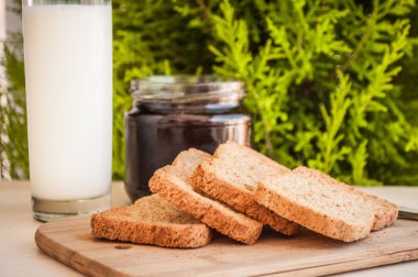 bir bardak süt ve meyve ile ekmek üzerine vişne reçeli ile kahvaltı