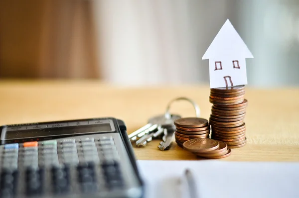 Pluma y llave y calculadora y casa de papel y monedas para el concepto de préstamos hipotecarios —  Fotos de Stock
