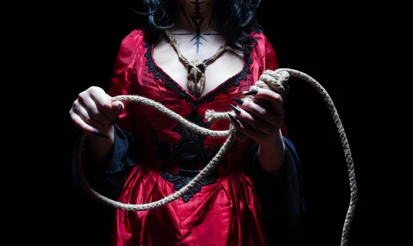 ゴシック様式のドレスに身を包んだ魔女や殺人者の女性の手には 鼻孔を閉じ込めた木製の動物の頭蓋骨のお守りが付いています ハロウィンのコンセプト — ストック写真