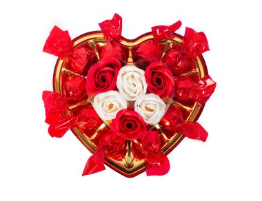 Romantik kalp şeklinde hediye paketi dolusu şeker ve gül. Beyaz arka planda, sevgili kız ya da kadın için bir hediye. Düz görüş. Sevgililer Günü, 8 Mart, aşk konsepti..