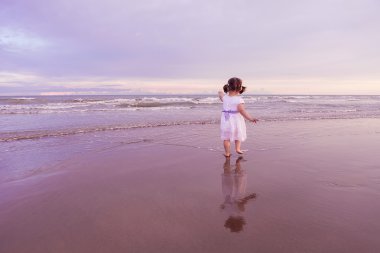 sunset bulvarında bir plaj boyunca yürüyüş şirin çocuk