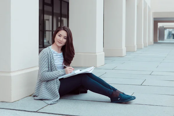 klasörleri dışında bina Üniversitesi adlı genç kızla gülümseyen