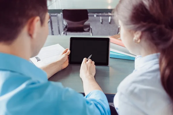 Genç öğrencinin öğrenmesini ve tablet kitaplığındaki yazmaya elleri