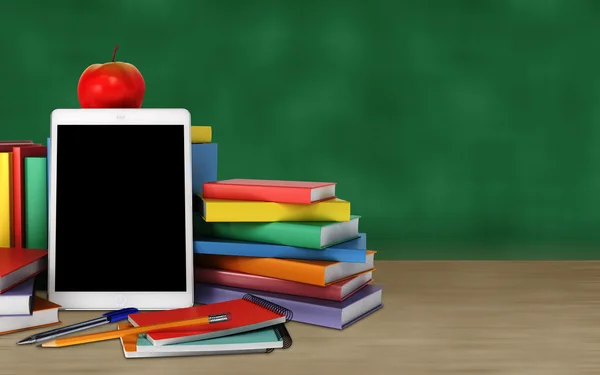 Tablet, colorful books, school supplies and apple on the table on blackboard background — Stock Photo, Image
