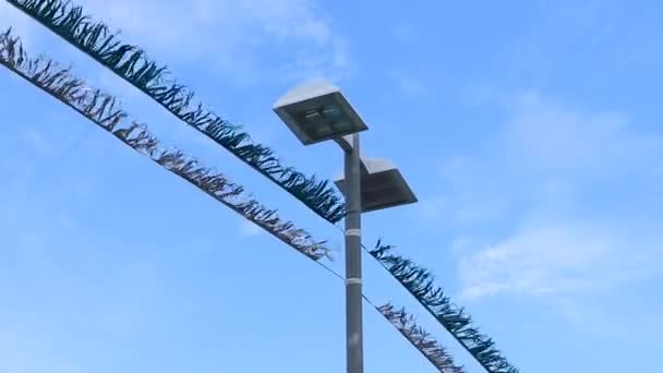 Shiny Tinsel Tied Post Flutters Wind Street Lamp Background — Stockvideo