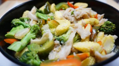 Sebzeli capcay mantarlı ve biberli taze mısır ve çömelmiş siyah bir renge yakın görülmüş.