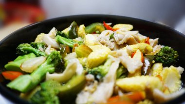 Sebzeli capcay mantarlı ve biberli taze mısır ve çömelmiş siyah bir renge yakın görülmüş.