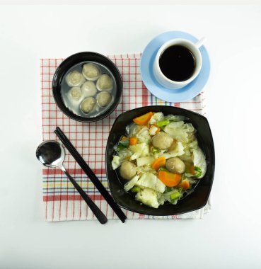 Salatalık turşulu sebze çorbası, havuç ve beyaz arka planda bir peçetede köfte..