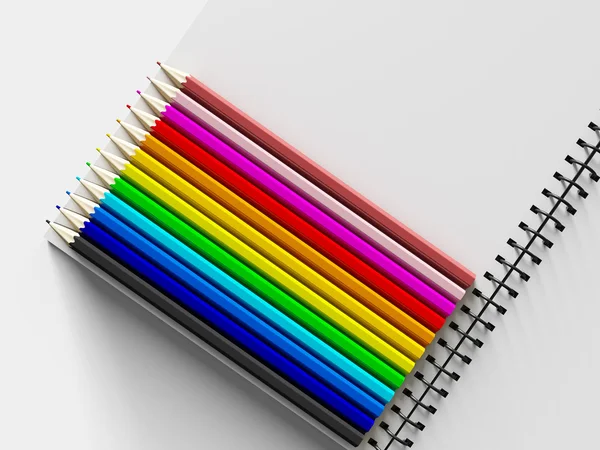 Notebook con matite colorate su sfondo bianco — Foto Stock