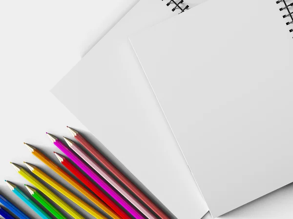 Notebook con matite colorate su sfondo bianco — Foto Stock