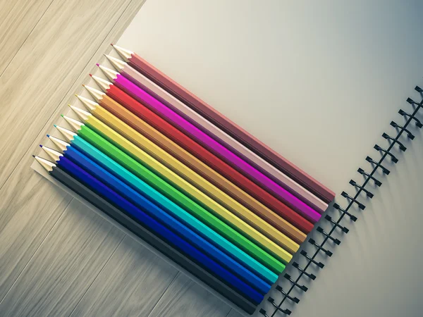 Crayon de couleur sur carnet à carreaux sur fond bois — Photo