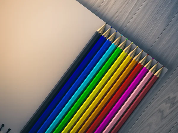 Кольоровий олівець на перевіреному ноутбуці на фоні дерева — стокове фото