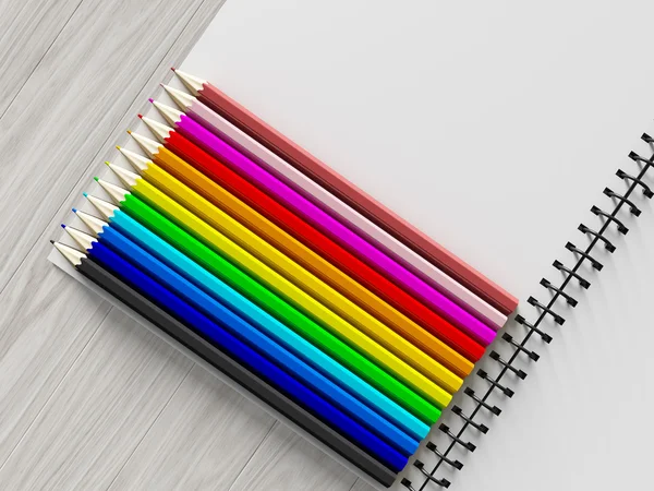 Lápiz de color en cuaderno comprobado sobre fondo de madera —  Fotos de Stock