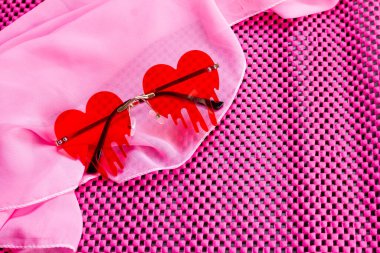 Pembe bir şalda eriyen kalp şeklinde kırmızı bardaklar.