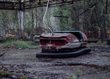 Pripyat şehrinin eğlence parkında terk edilmiş eski bir araba.