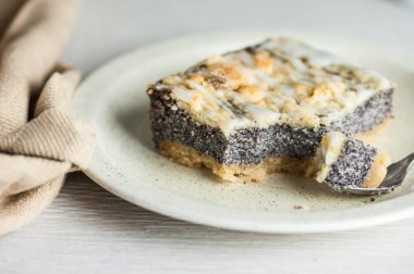 Beyaz bir yüzeyde haşhaşlı kekten bir dilim, yakın plan.