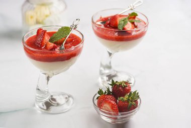İki bardak geleneksel kremalı tatlı panna cotta naneli, çilekli reçelli, taze çilekli