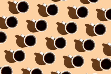 Bej yüzeydeki bir kahve fincanının renkli sert ışık deseni