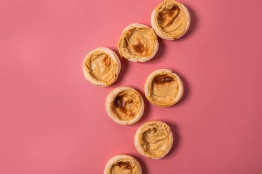Portekiz tatlı pastası pastel de nata. Pembe arka planda üst görüntü.