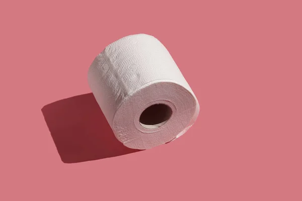 Pembe Bir Yüzeyde Beyaz Bir Tuvalet Kağıdı Rulosu — Stok fotoğraf
