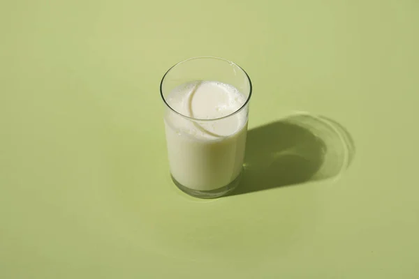 Стакан Молока Пастельно Зеленой Поверхности Твёрдой Светлой Тенью — стоковое фото