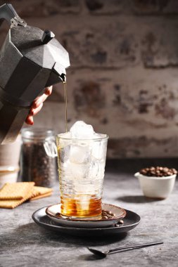 Moka espresso makinesinden buzlu bir bardağa kahve dolduruyorum.