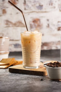 Pirinç kamışlı, tahtanın üzerinde buzlu ve sütlü bir bardak.