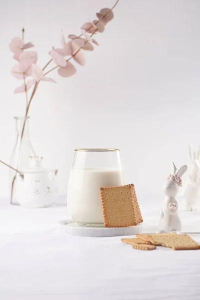 白いテーブルクロスに大理石のプレート上の牛乳のガラス 焼きたてのクッキー 白いイースターバニー フィギュア — ストック写真