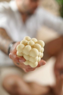 Beyaz baloncuk mumu tutan bir erkek el.