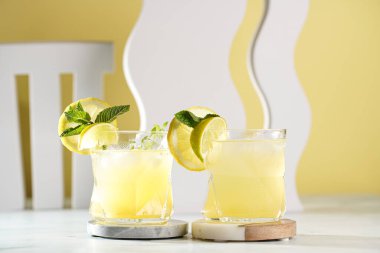 Düzensiz bardakta limon ve naneli iki buzlu limonata.