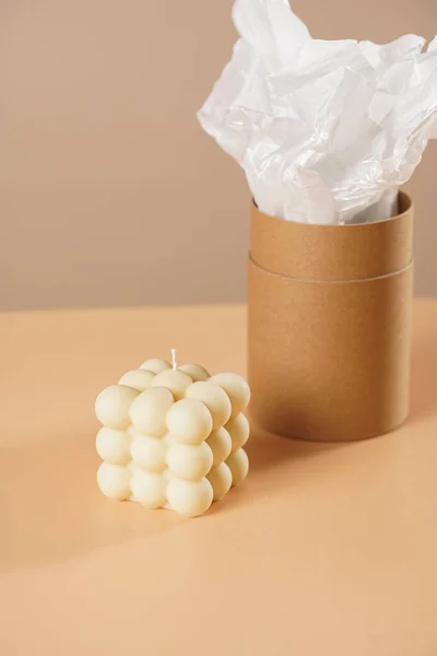 Eine Pastellgelbe Blasenkerze Auf Beigefarbenem Hintergrund Und Eine Zylinderverpackung Aus — Stockfoto