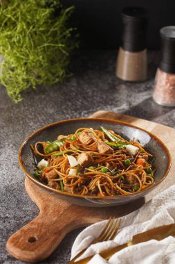 Tavuklu İtalyan makarna, yeşil fasulye, peynirli mozzarella ve yeşil kasede kekik gri beton yüzeyde tahta tahtada.