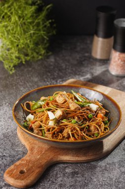 Tavuklu İtalyan makarna, yeşil fasulye, peynirli mozzarella ve yeşil kasede kekik gri beton yüzeyde tahta tahtada.