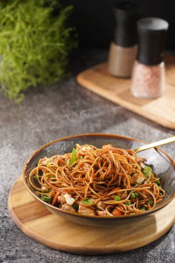 Tavuklu İtalyan makarna, yeşil fasulye, peynirli mozzarella ve yeşil kasede kekik gri beton yüzeyde tahta tahtada.