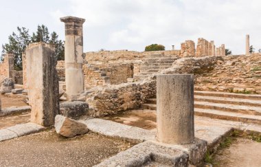 Kıbrıs 'taki Apollo Hylates Sığınağı' nın antik kalıntıları, yıpranmış taş yapılar ve parlak Akdeniz ışığı altında ayakta duran sütunlar yer alıyor.