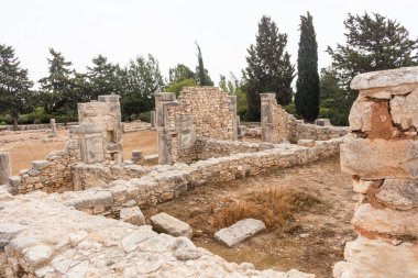 Kıbrıs 'taki Apollo Hylates Sığınağı' nın antik kalıntıları, yıpranmış taş yapılar ve parlak Akdeniz ışığı altında ayakta duran sütunlar yer alıyor.