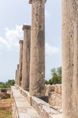 Kıbrıs 'taki Apollo Hylates Sığınağı' nın antik kalıntıları, yıpranmış taş yapılar ve parlak Akdeniz ışığı altında ayakta duran sütunlar yer alıyor.