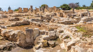 Kıbrıs 'taki Apollo Hylates Sığınağı' nın antik kalıntıları, yıpranmış taş yapılar ve parlak Akdeniz ışığı altında ayakta duran sütunlar yer alıyor.