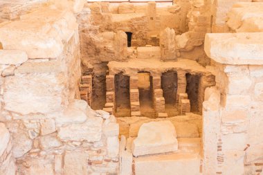 Kıbrıs 'taki Apollo Hylates Sığınağı' ndaki antik banyo kalıntıları, doğal ışık altında eskimiş taş kalıntıları ve tarihi mozaik parçalarının yer aldığı antik bir yapı.