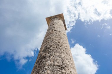 Kıbrıs 'taki Apollo Hylates Sığınağı' nın antik kalıntıları, yıpranmış taş yapılar ve parlak Akdeniz ışığı altında ayakta duran sütunlar yer alıyor.