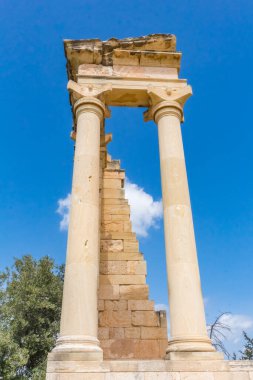 Kıbrıs 'taki Apollo Hylates Sığınağı' nın antik kalıntıları, yıpranmış taş yapılar ve parlak Akdeniz ışığı altında ayakta duran sütunlar yer alıyor.