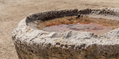 Kıbrıs 'taki Apollo Hilates Sığınağı' nda suyla dolu eski taş havzada antik zanaatkarlık ve tarihi mekanın sakin atmosferi sergileniyor.