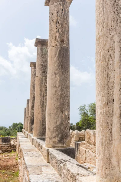 Kıbrıs 'taki Apollo Hylates Sığınağı' nın antik kalıntıları, yıpranmış taş yapılar ve parlak Akdeniz ışığı altında ayakta duran sütunlar yer alıyor.