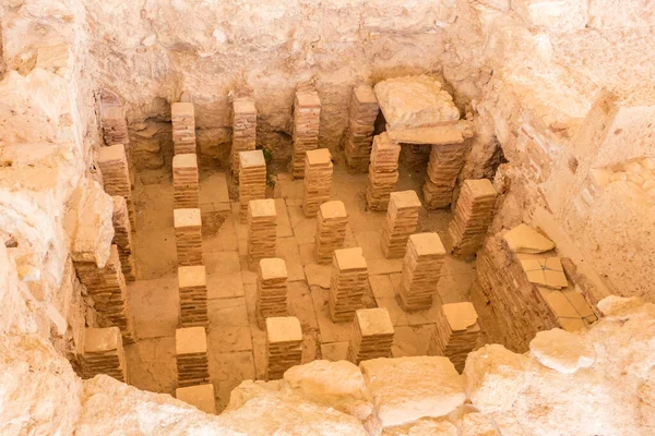 Kıbrıs 'taki Apollo Hylates Sığınağı' ndaki antik banyo kalıntıları, doğal ışık altında eskimiş taş kalıntıları ve tarihi mozaik parçalarının yer aldığı antik bir yapı.