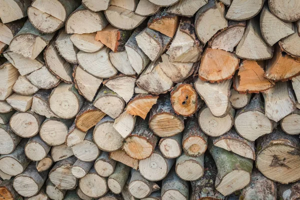 Doğal ahşap dokusunu gösteren parçalanmış ve istiflenmiş odunların yakın çekimi. Tahıl desenleri, kaba yüzeyler ve kırsal organik maddeler hakkında detaylı bir görüş.