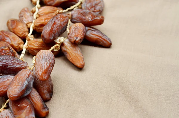 Tarihler (Phoenix dactylifera) kahverengi kumaş arka planda ahşap bir kase üzerinde. Müslümanlar için Ramazan ayında oruç tutmak. seçici odak