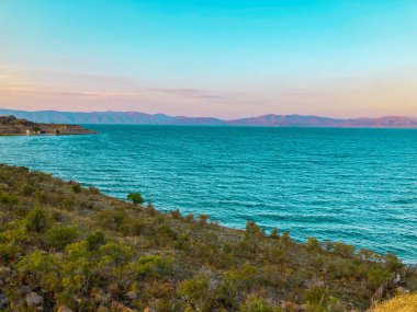 Turkuaz suyu ve yeşil tepeleri olan Sevan Gölü manzarası, Sevan, Ermenistan