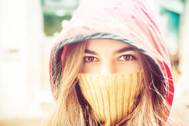 Sarışın, beyaz bir kız ağzı kapalı ve kafasında bir başlıkla bize bakıyor.